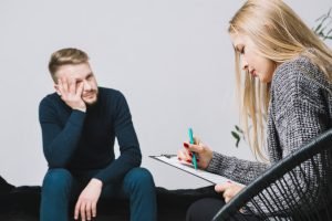 Psychologist consulting a male client during a therapy discussion