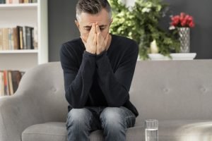 Man sitting on a couch during a therapy session at a mental health clinic