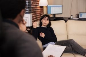 Woman in a psychotherapy session talking with a therapist about stress and problems