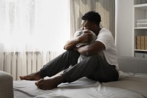 Young adult sitting at home feeling depressed, seeking mental health support in Hagerstown, MD