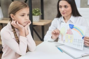 Psychologist working with a young client during a therapy session